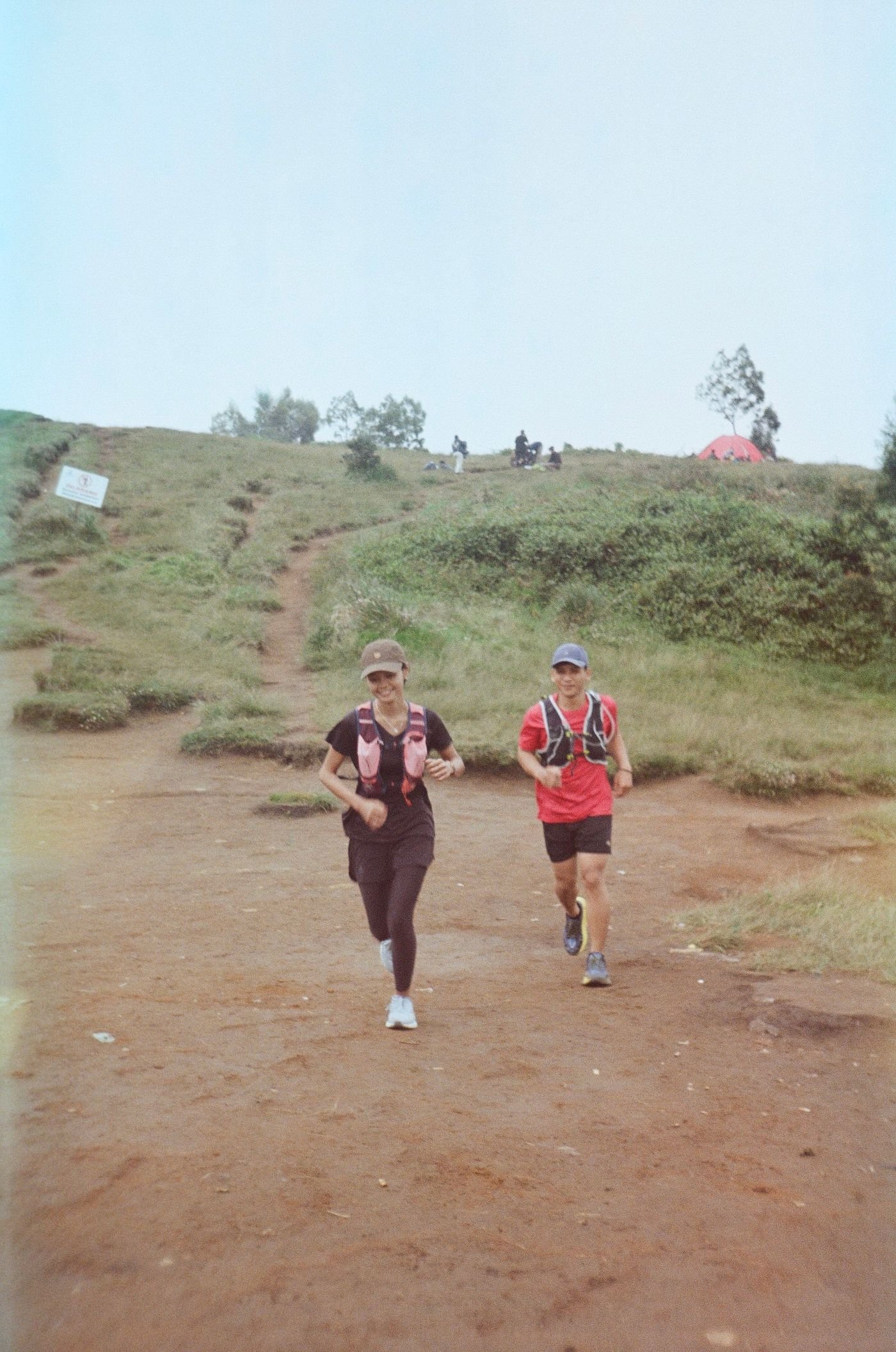 Two runners jogging uphill on a trail