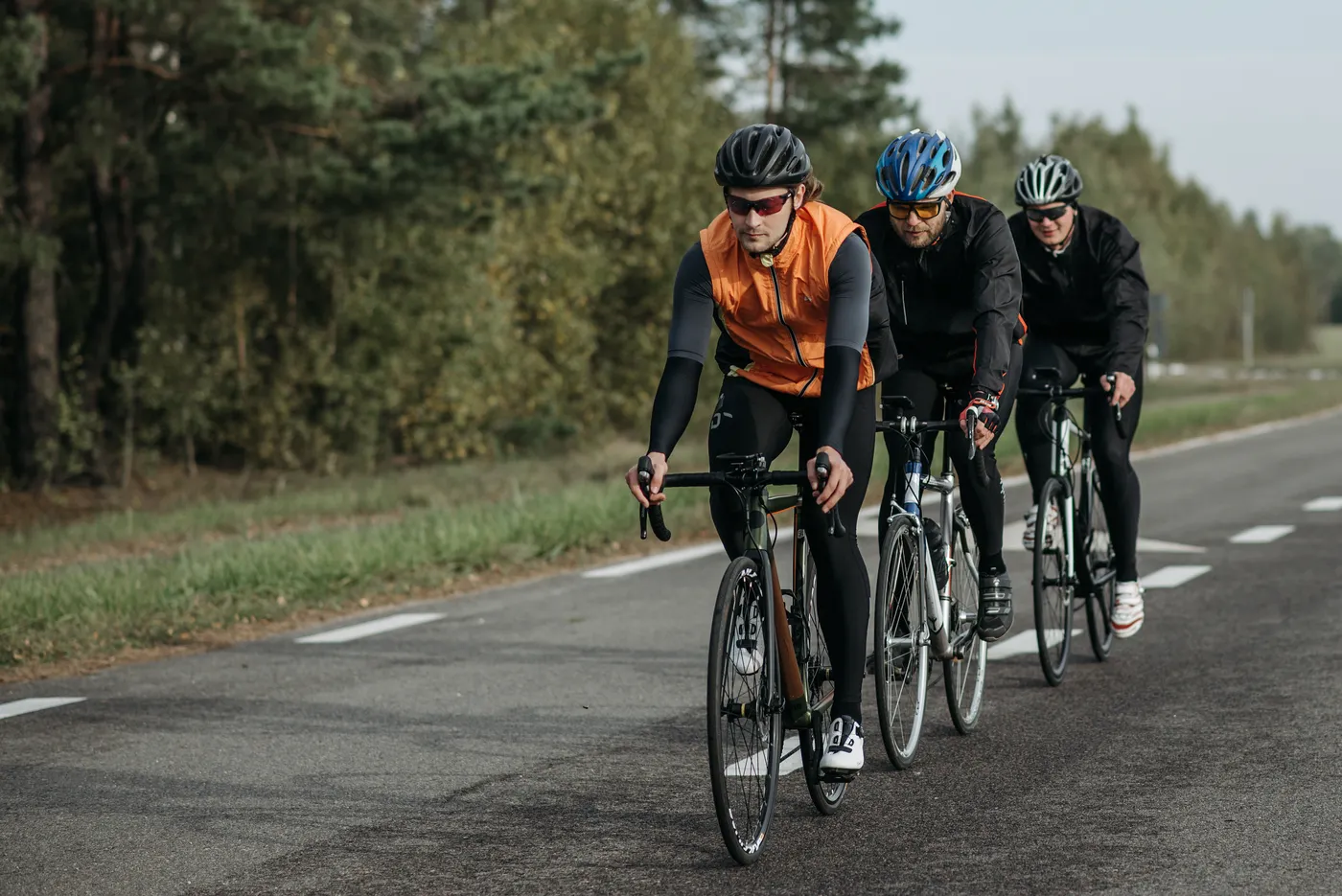 Endurance cyclists riding together on a tree-lined road