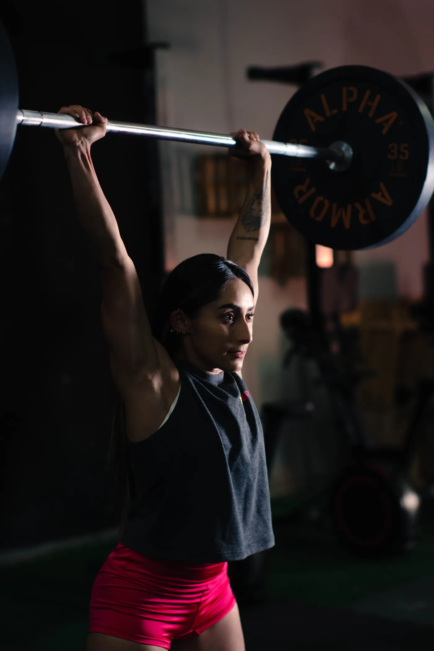 Woman lifting a loaded barbell during strength training