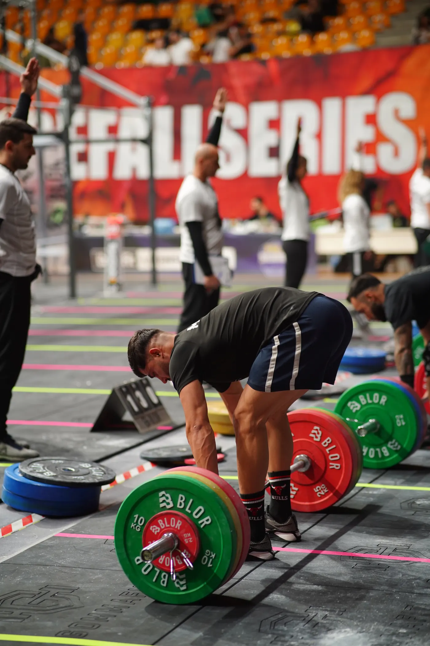 Athletes performing demanding barbell lifts indoors