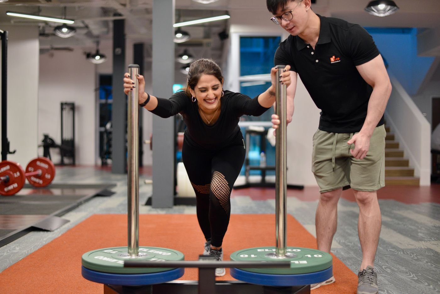 Woman learning sled technique with a trainer