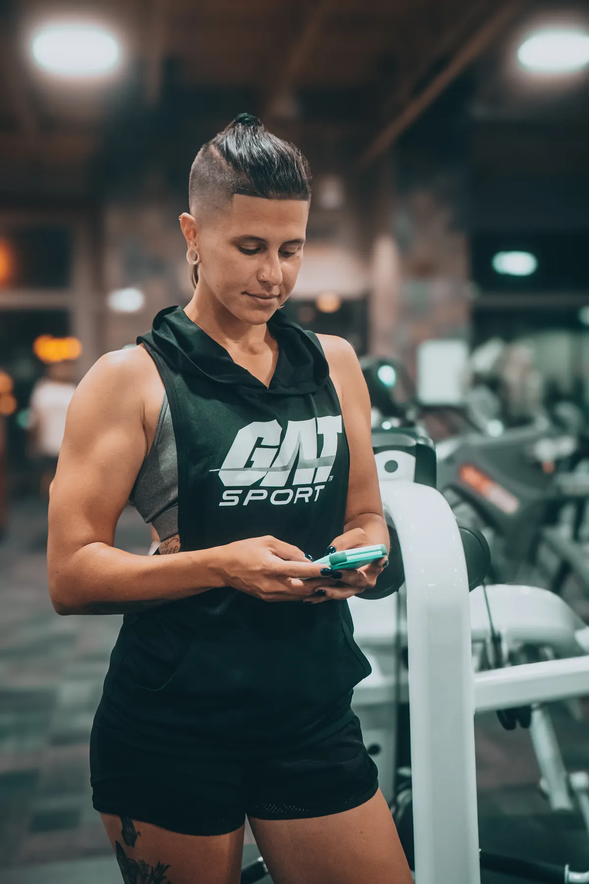 Athlete checking a phone between sets to track training performance