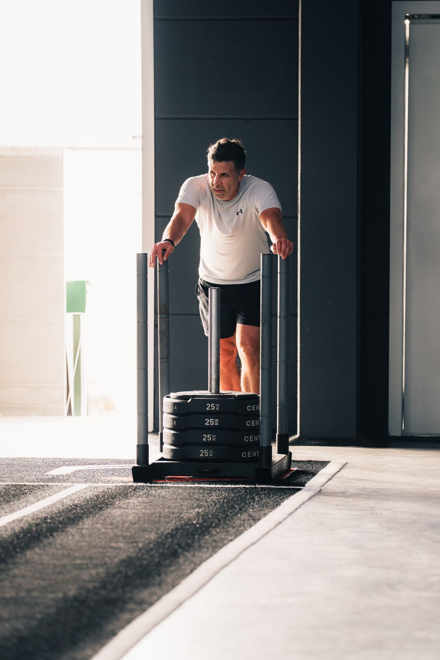 Man pushing a weighted sled in a gym