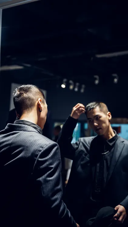 Man checking and styling his hair in a mirror