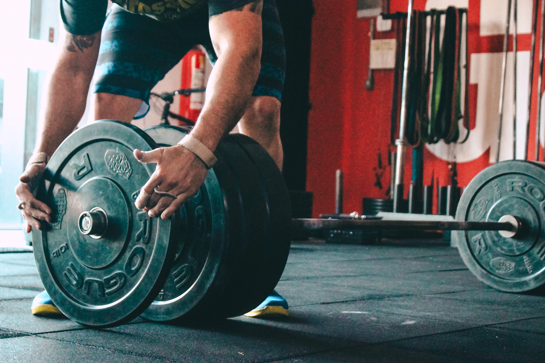 Lifter preparing a barbell by handling a weight plate