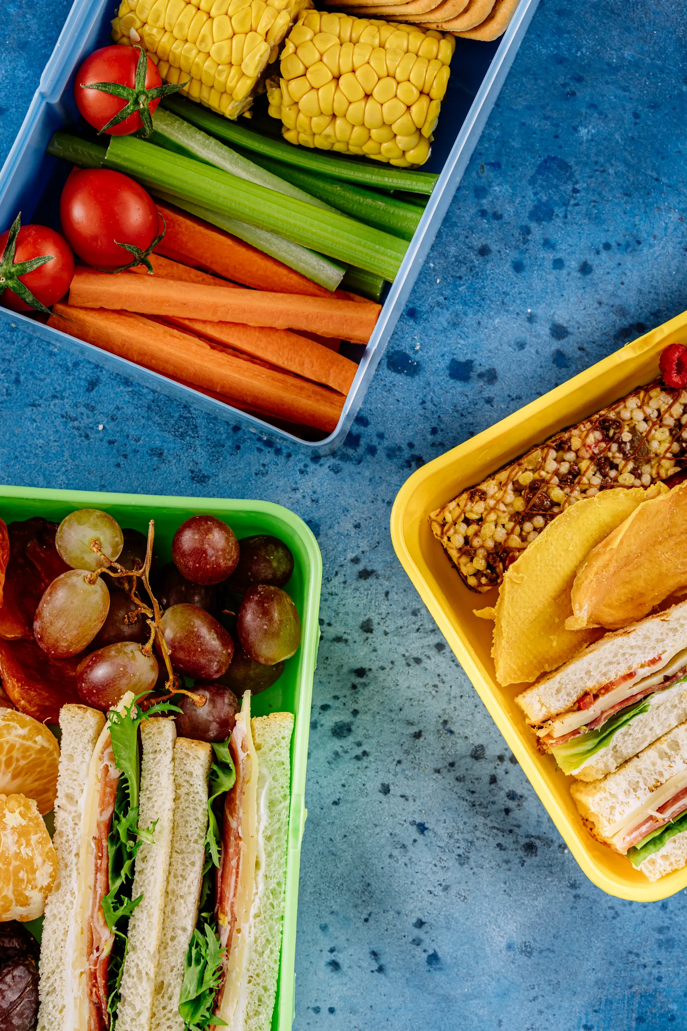 Packed lunchboxes containing sandwiches, fruits and vegetables