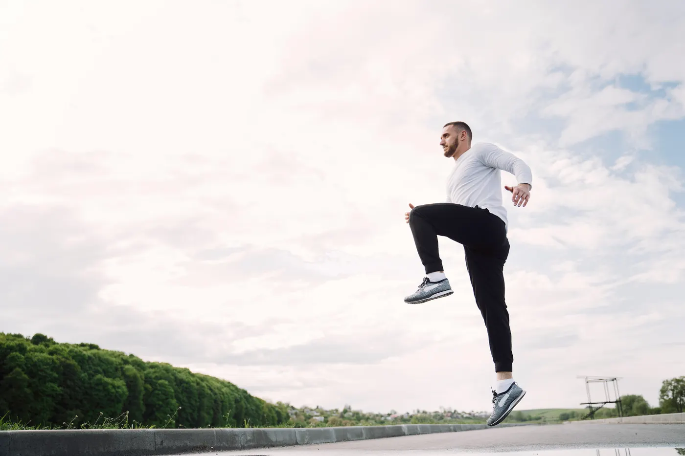 Athlete practicing an explosive jump outdoors with full-body extension