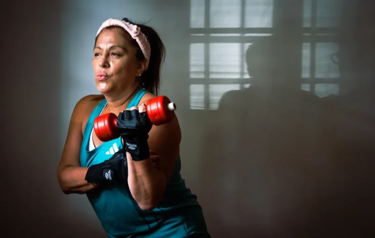 Middle-aged woman lifting a dumbbell indoors