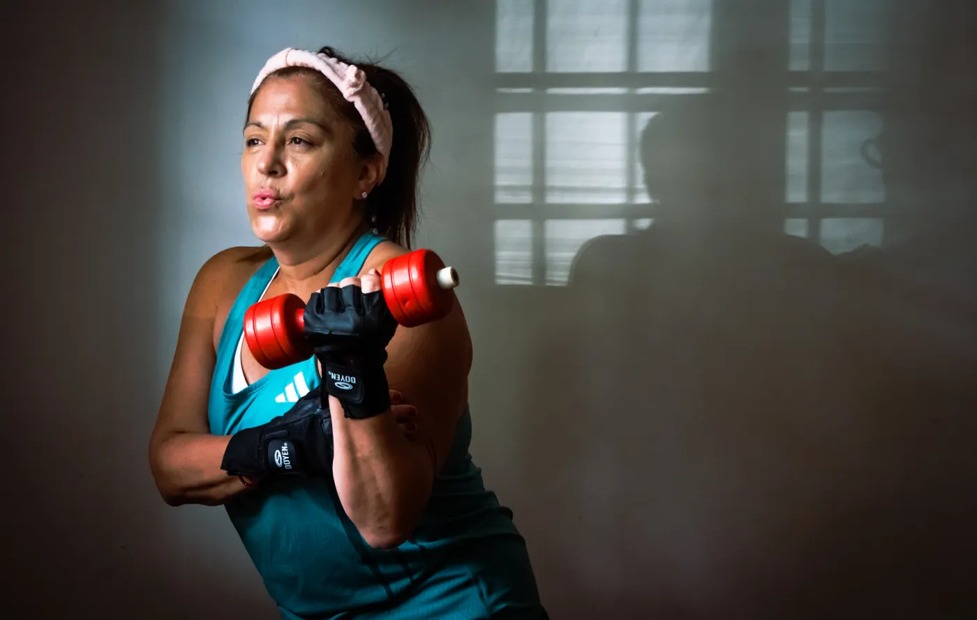 Middle-aged woman lifting a dumbbell indoors