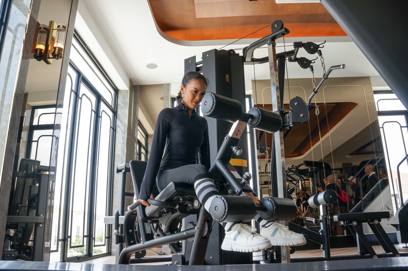 Woman performing a seated leg curl in a gym