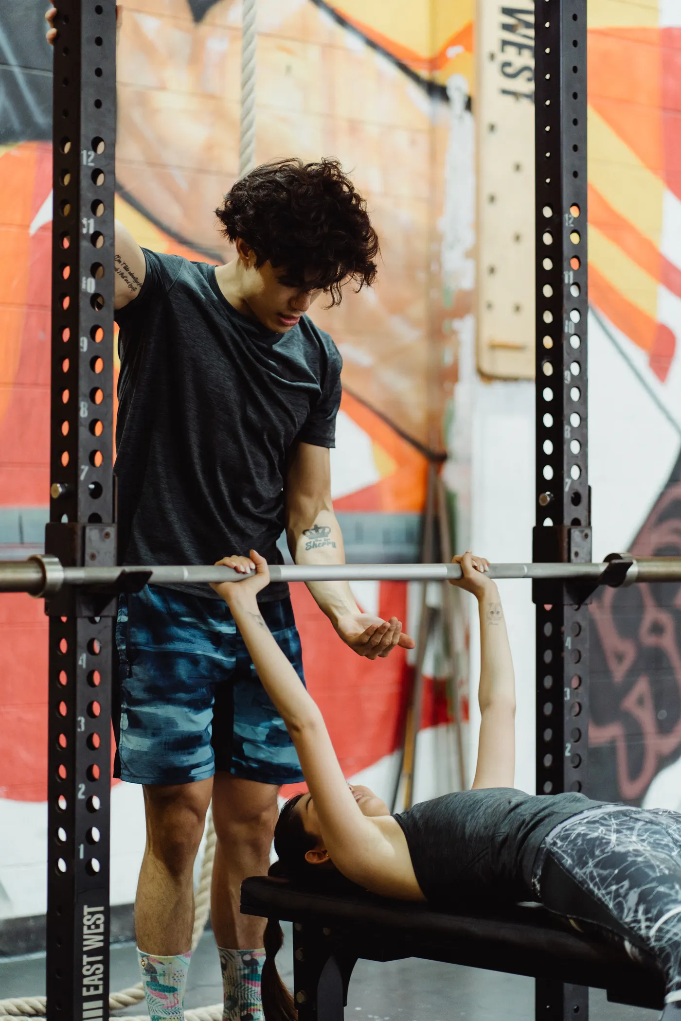 Trainer assisting a woman during a bench press