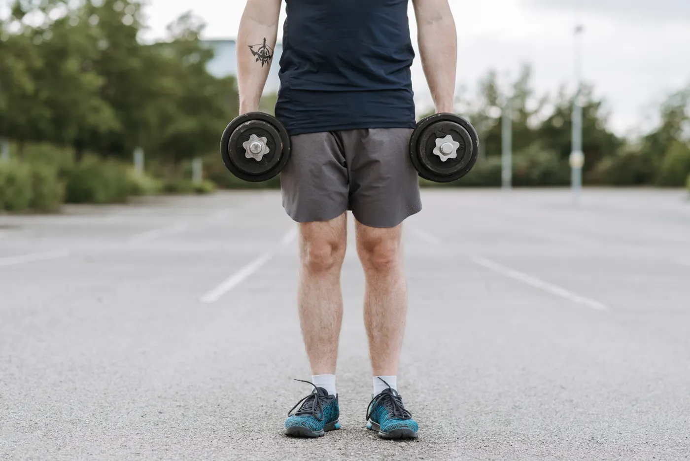 Close view of hands gripping dumbbells during strength training