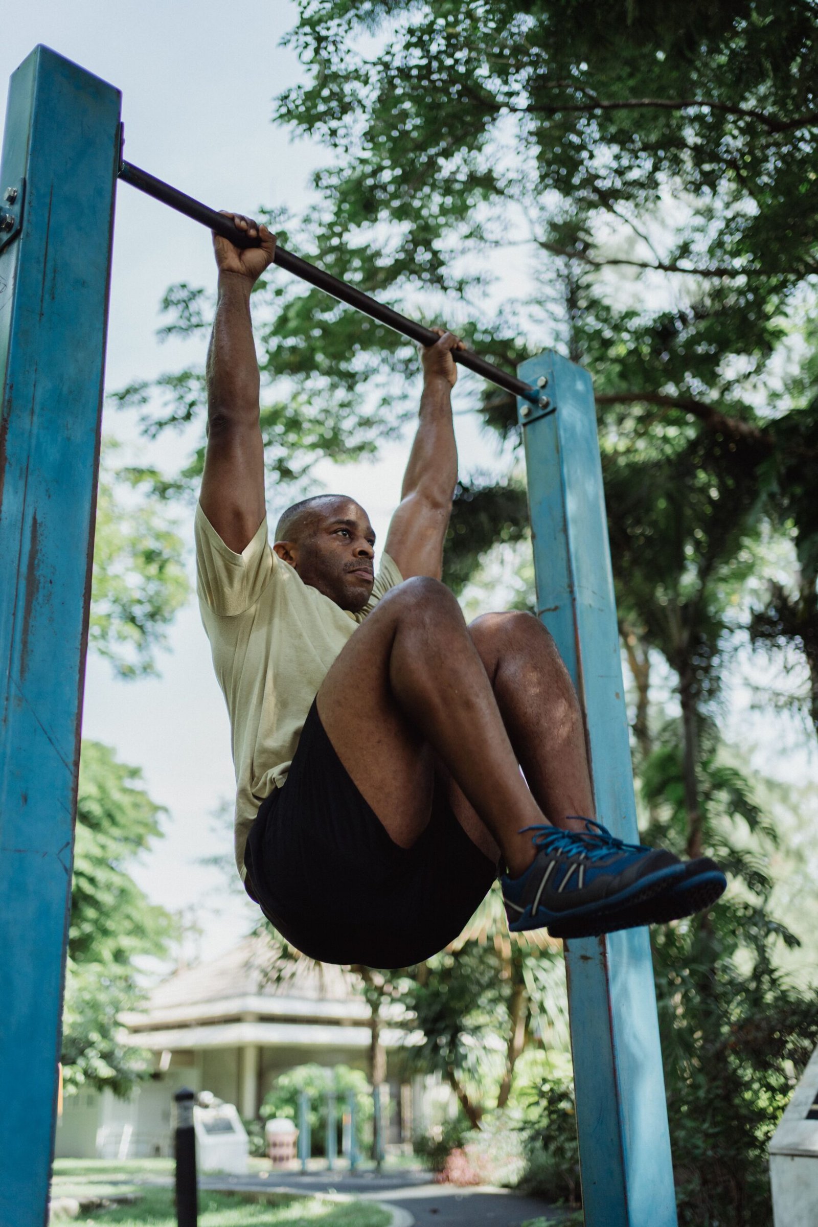 Athlete hanging from a pull-up bar and raising his knees