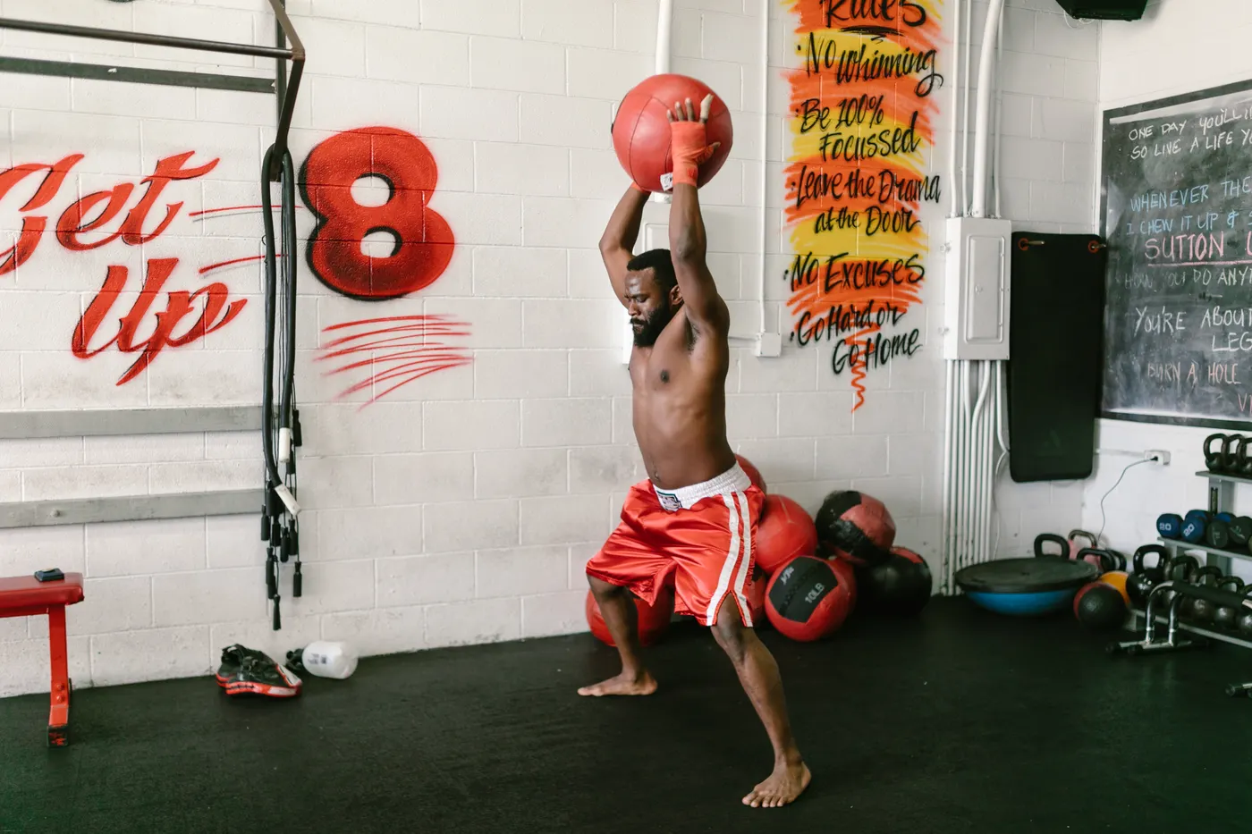 Man lifting a medicine ball overhead during gym training