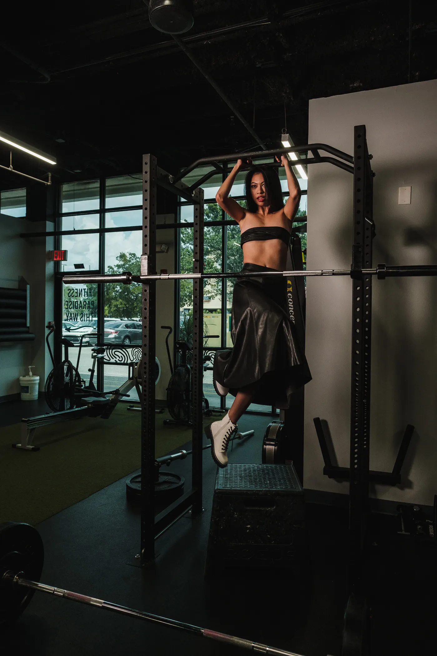 Woman hanging from a pull-up bar during a training session