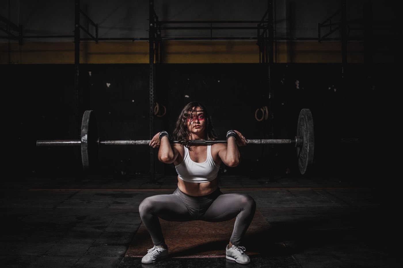 Woman performing a barbell squat during lower-body training
