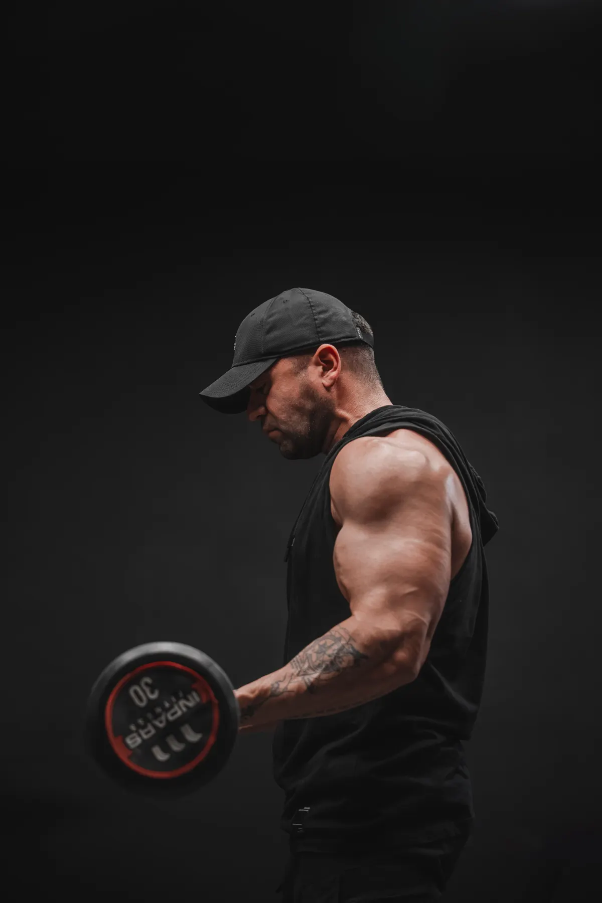 Man performing a dumbbell strength exercise in a gym