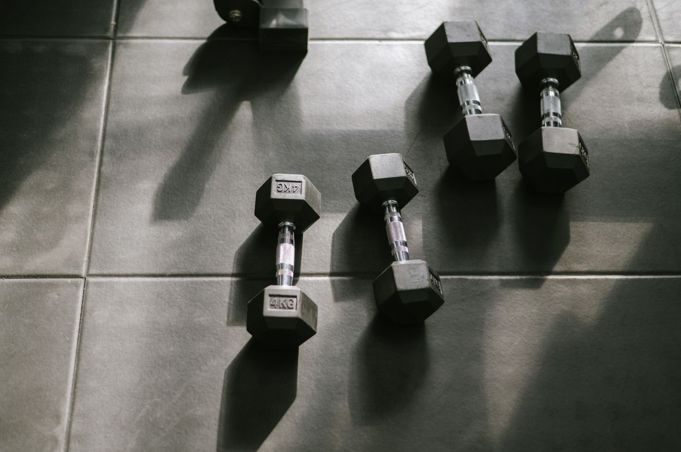 Hex dumbbells on a gym floor in natural light