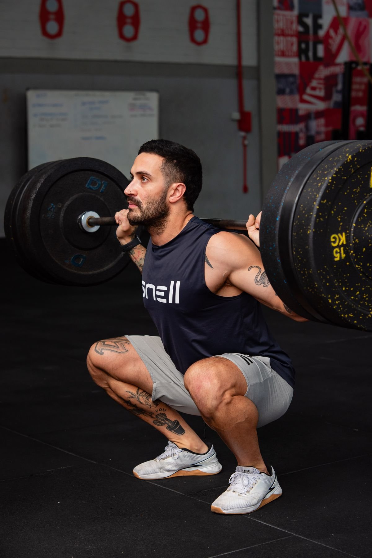 Athlete performing a heavy barbell squat in an indoor gym