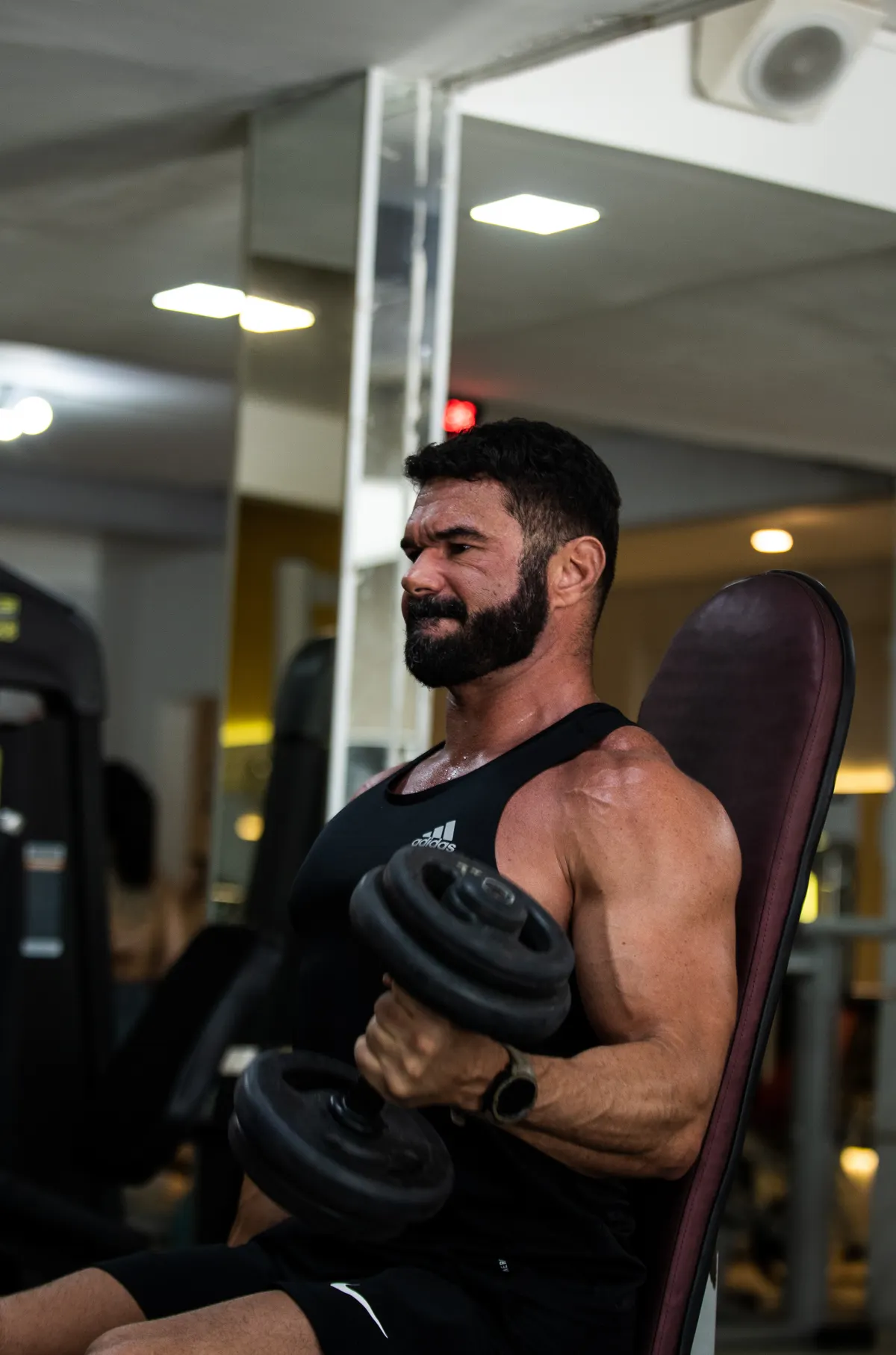 Man performing a dumbbell exercise in a gym