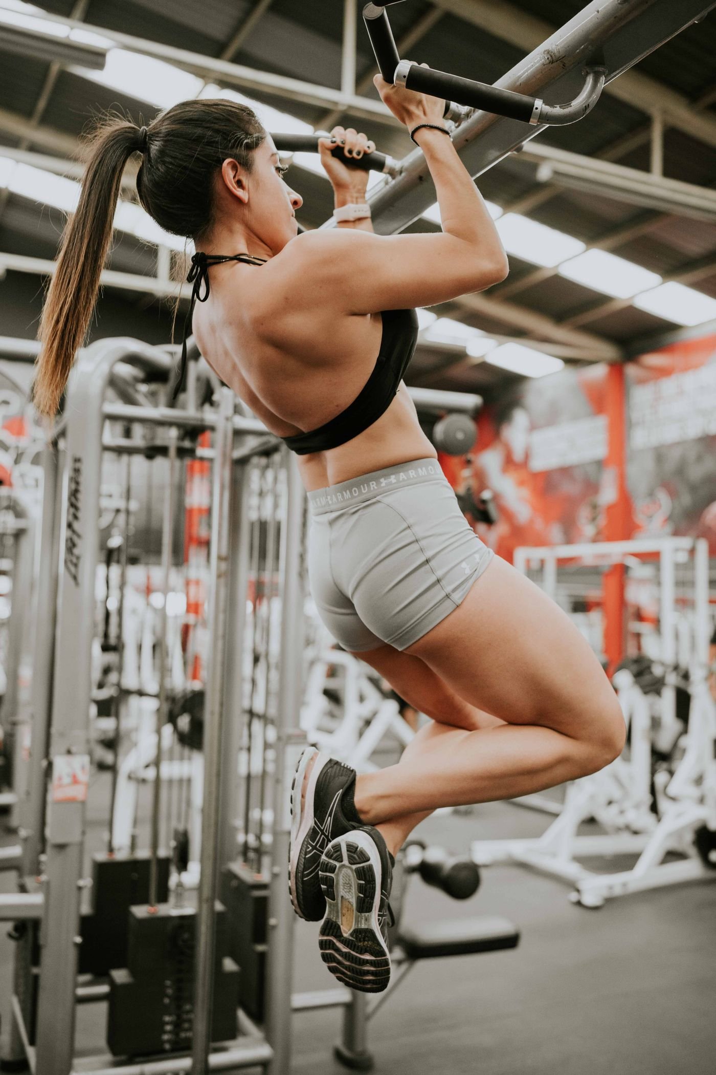 Woman performing a strict pull-up in a gym