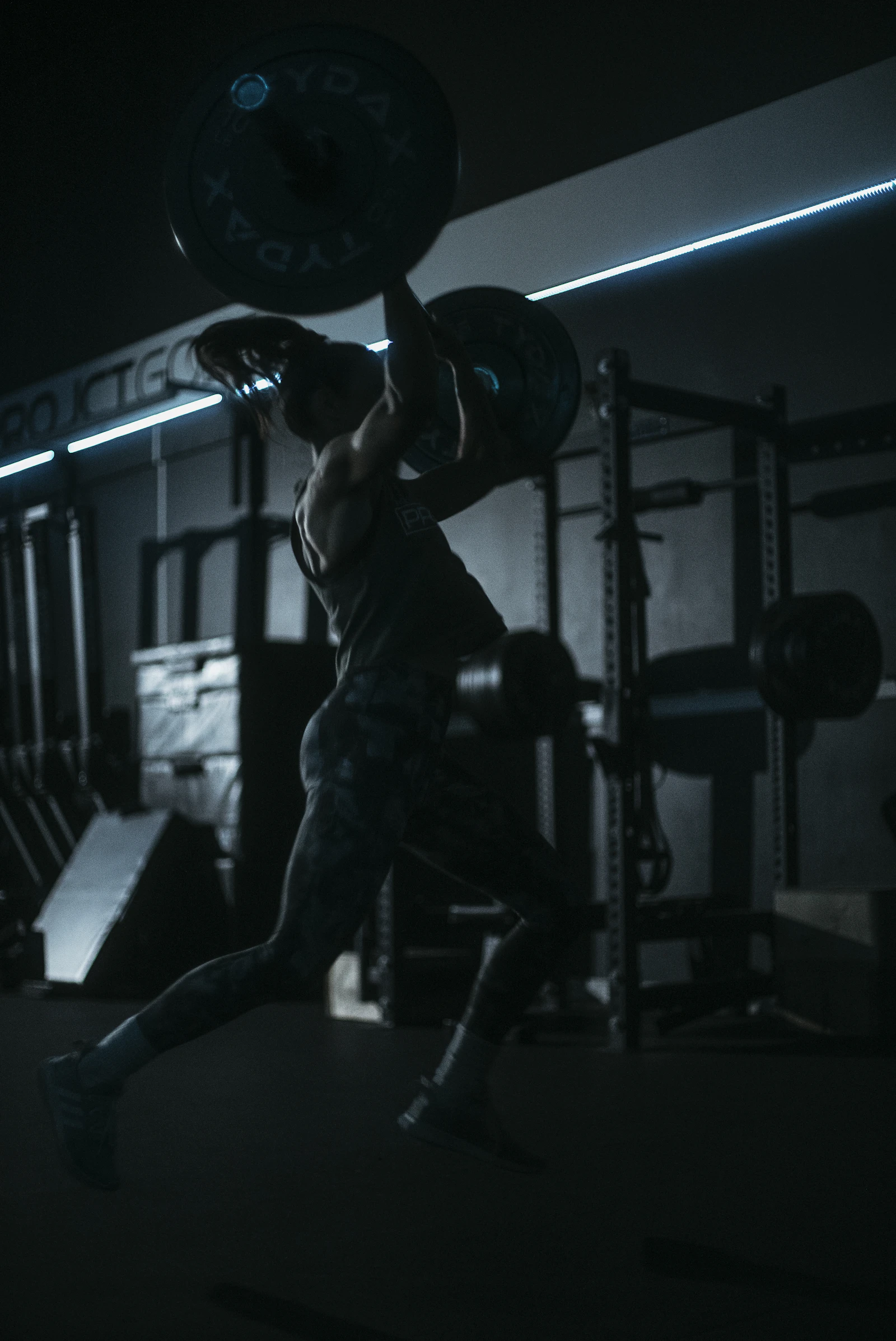 Lifter handling a barbell in a dark gym